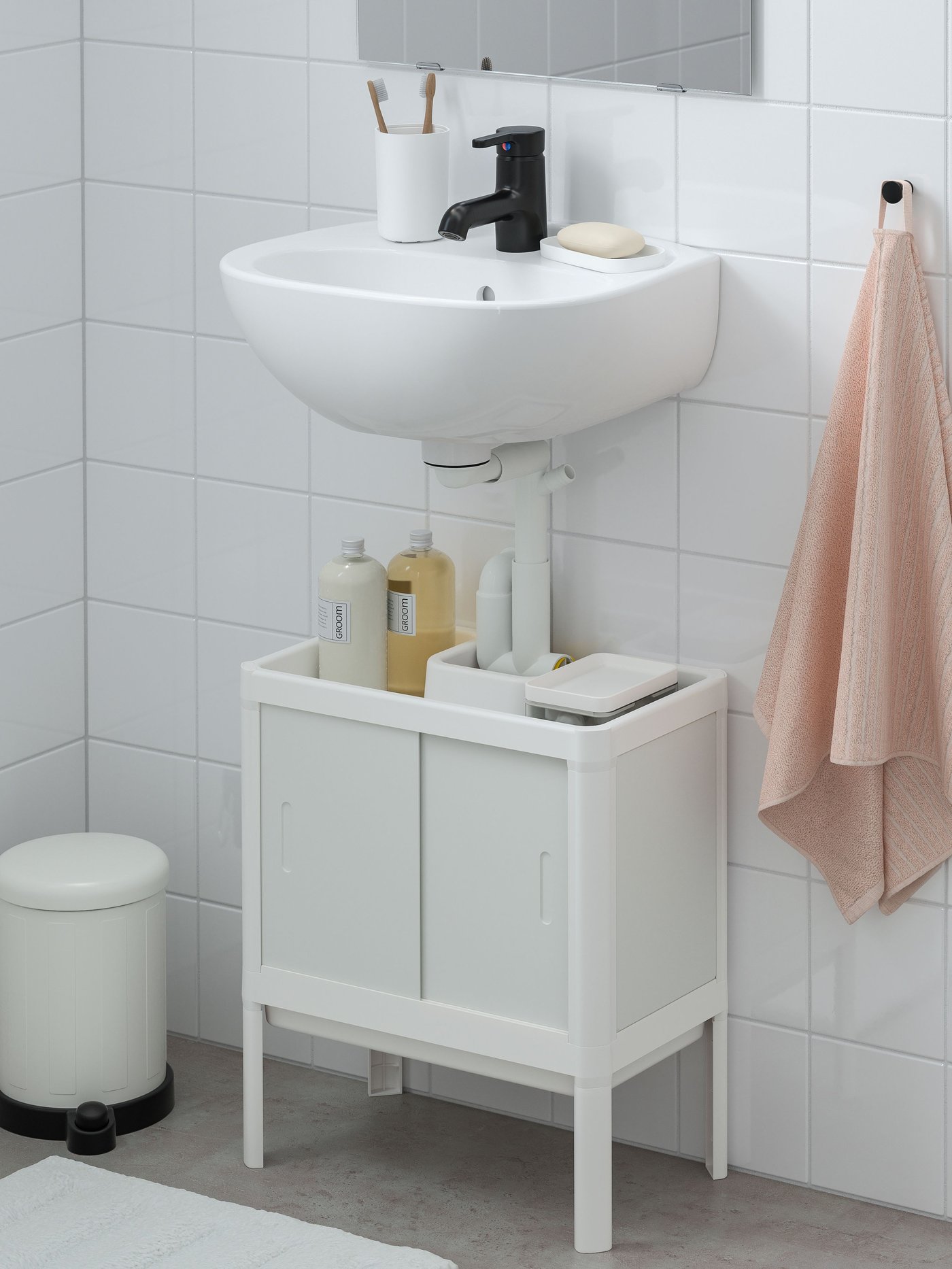 Un mueble para lavamanos LILLTJÄRN de dos puertas con una bandeja en la parte superior debajo de un lavamanos IKEA.