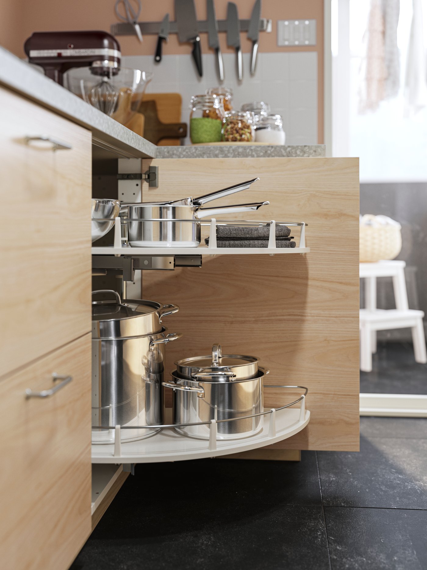 Ollas IKEA 365+ de acero inoxidable con tapa en un mueble bajo esquinero UTRUSTA con herraje extraíble en un mueble efecto fresno claro.