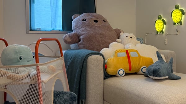 ふわふわのぬいぐるみがベッドにある、柔らかな印象の部屋。