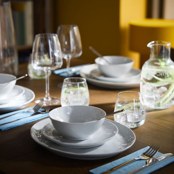 A SKANSNÄS extendable table is set with FORELLTETRA bowls and plates, DYRGRIP glasses and LÖFTESRIK cutlery.