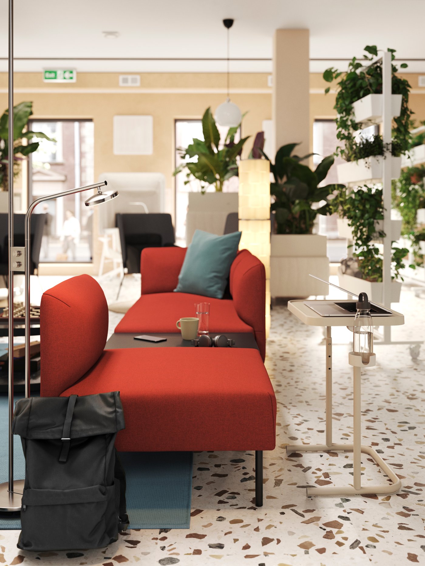 A lounge has a laptop table by a red LILLEHEM modular sofa, built in a straight line with an open end, viewed from the side.