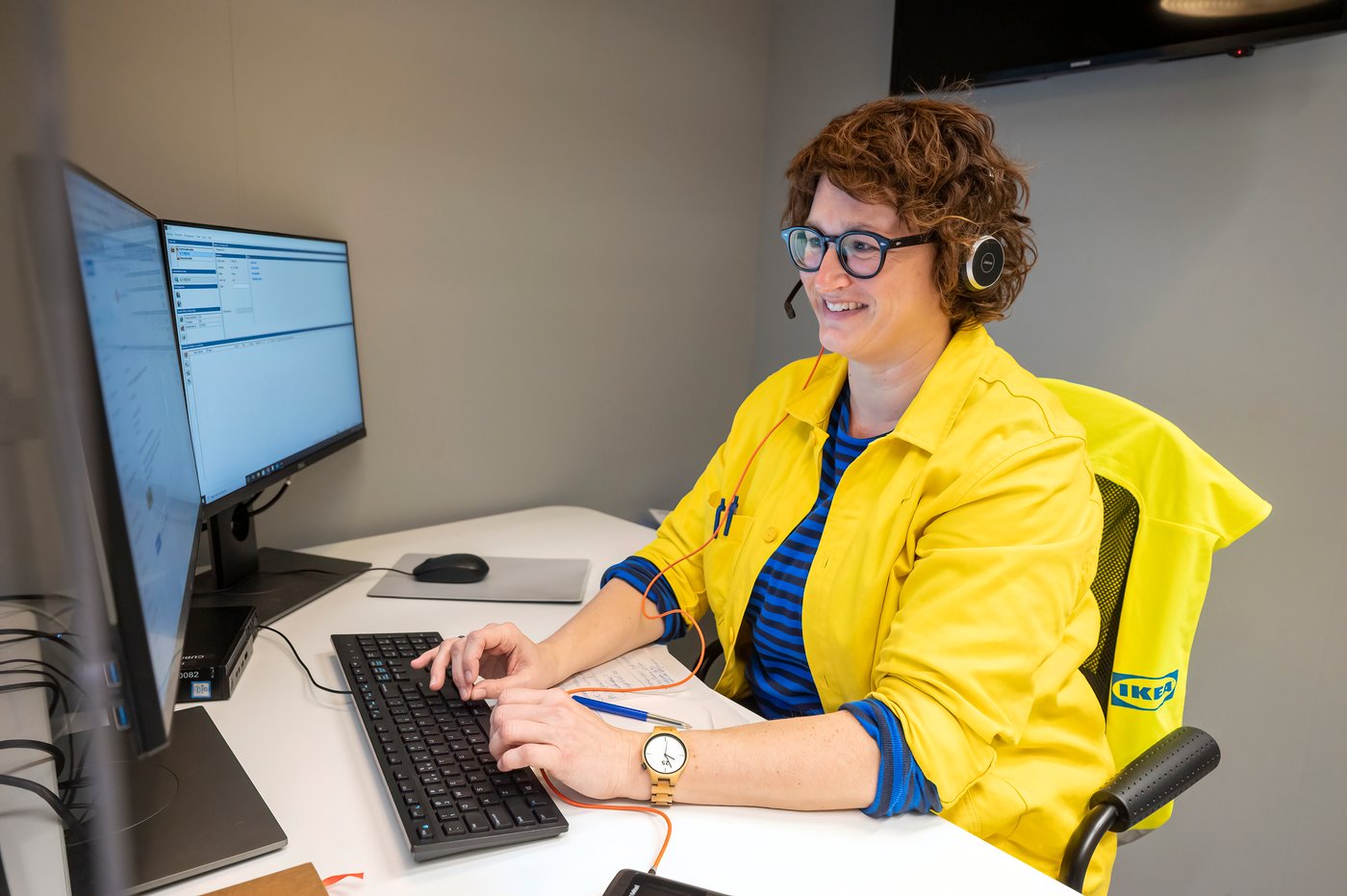 Een IKEA medewerkster lachend in haar gele uniform