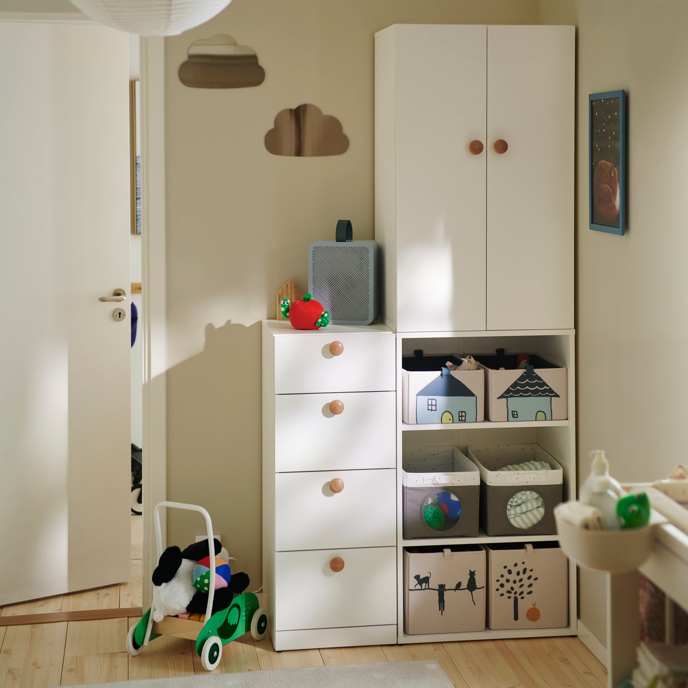 A LASTARE wardrobe combination in white with drawers and open shelves holding storage boxes, in a neutral children’s room.