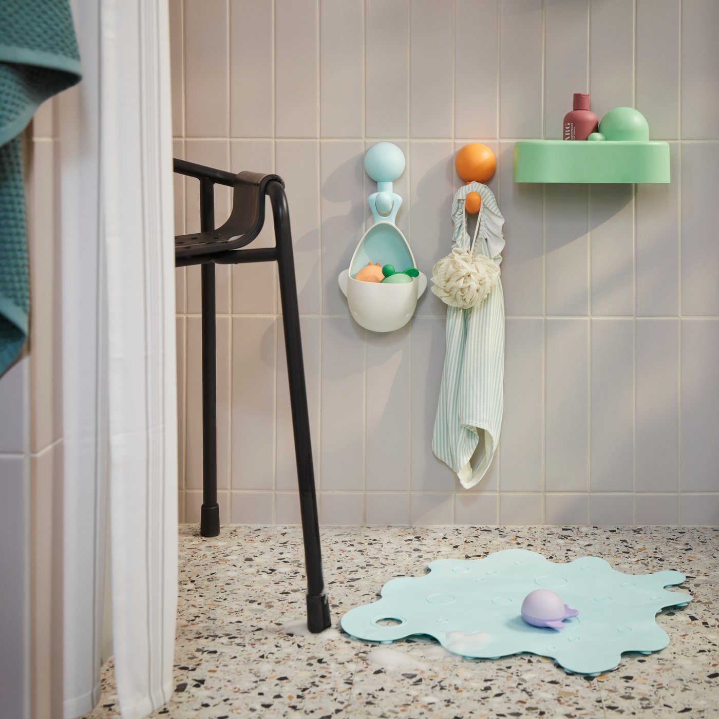 The ÄNGSHUMLA whale bath toy is attached to a bathroom wall with two of the other toys inside. Another toy is on the floor.