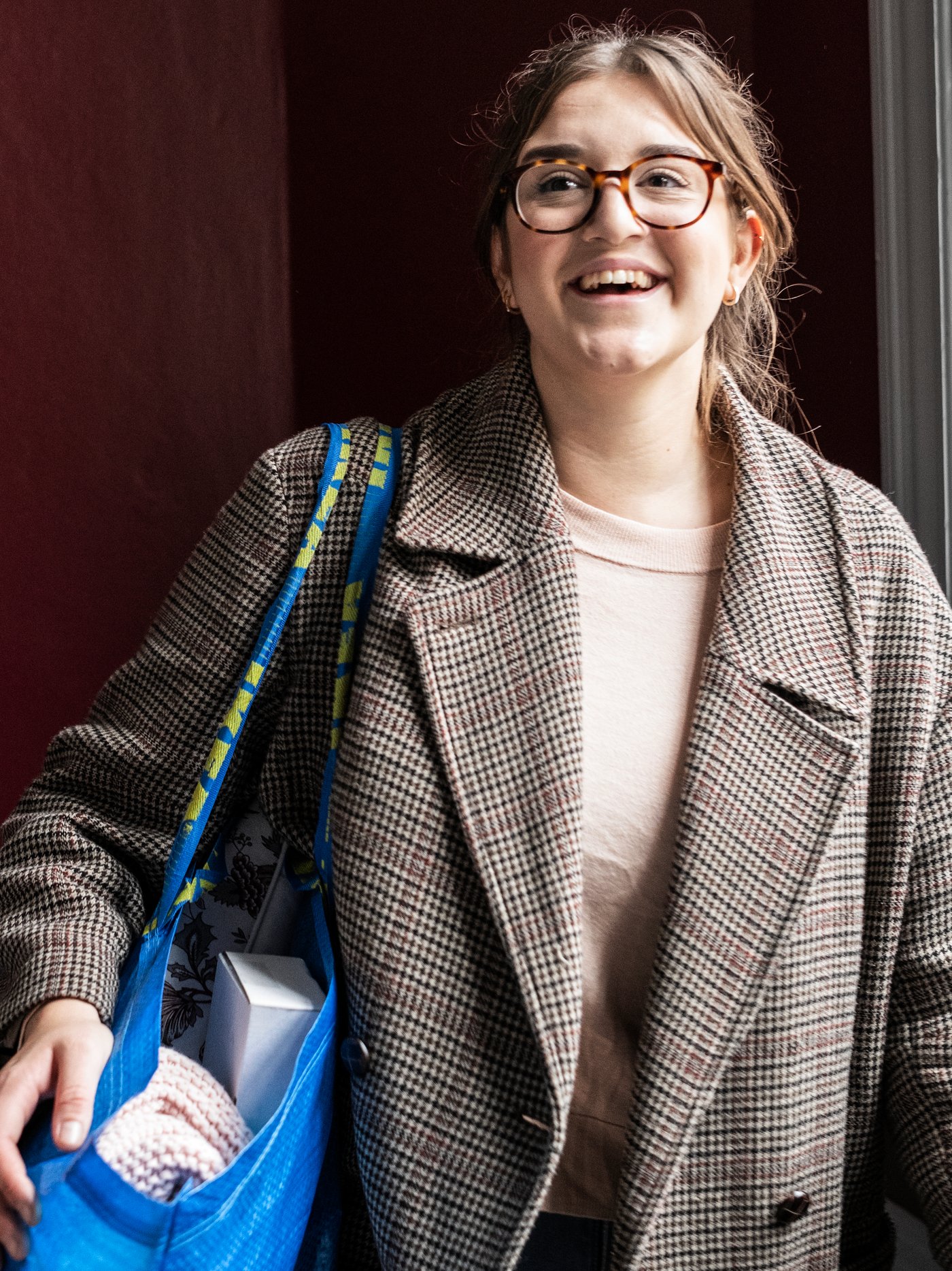 IKEA customer carrying a blue FRAKTA shopping bag filled with products