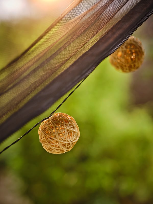 Detalle de una guirnalda luminosa enganchada sobre la rama de un árbol.