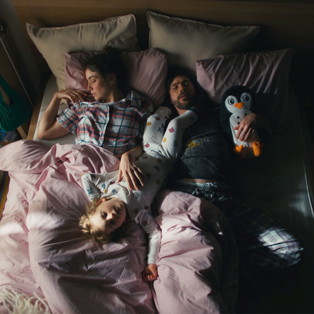 Couple and child sleeping in a bed