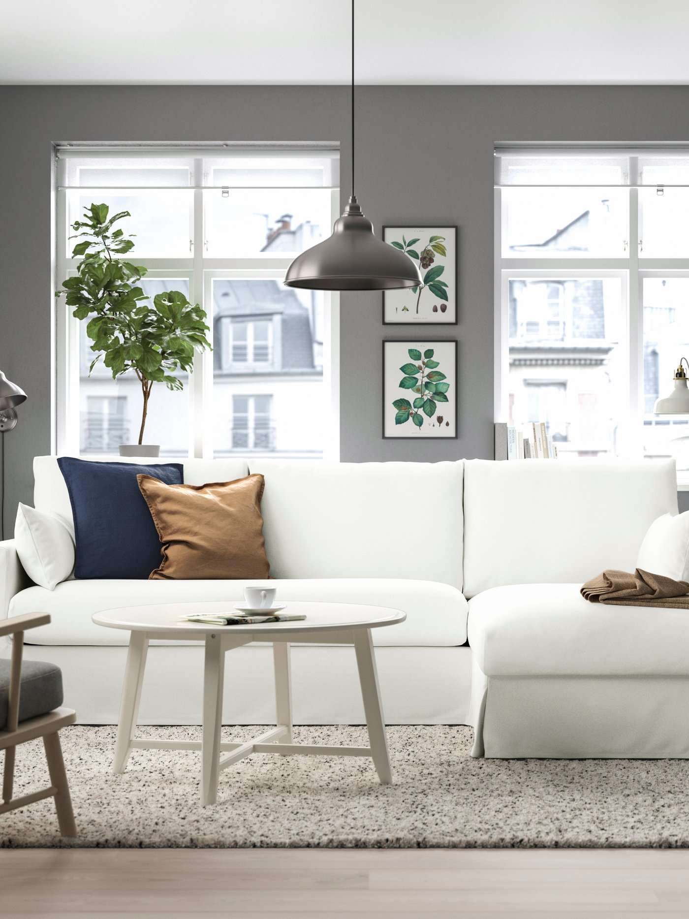 Olohuoneessa ikkunoiden edessä on valkoinen HYLTARP-sohva, jossa on divaani.