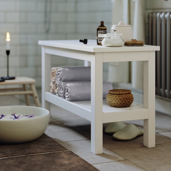 Biała ławka łazienkowa HEMNES stojąca w łazience obok miski.