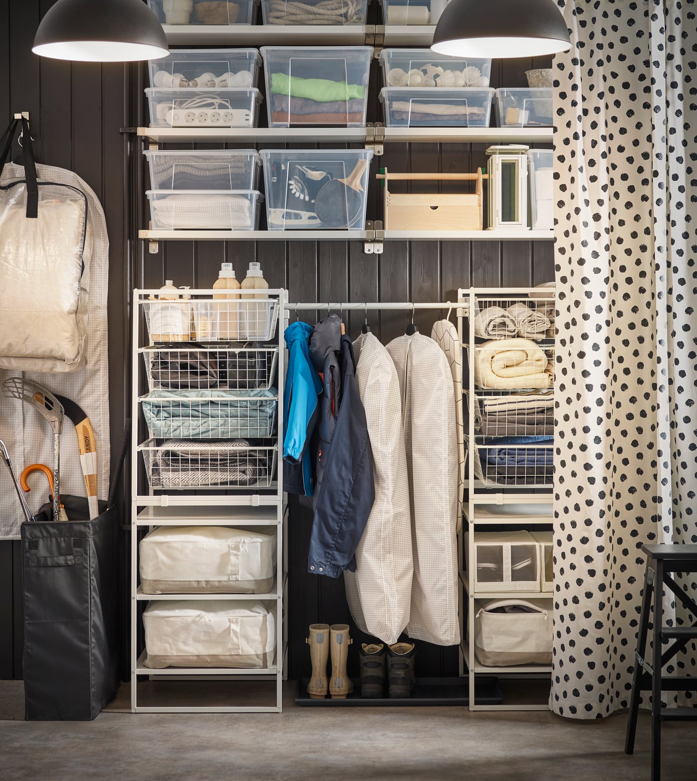 Sistem rak terbuka JONAXEL di ruang mencuci pakaian dengan bakul pakaian dan kotak storan di atasnya.