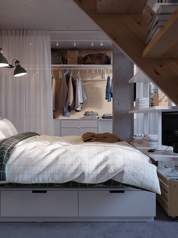 Ein weißes Bett aus unserer NORDLI Serie steht vor unsere IKEA Kästen.