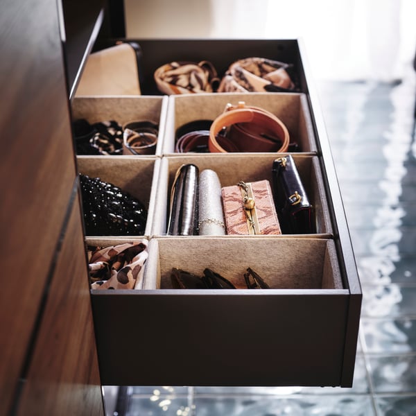 Close-up of wardrobe with sliding doors, one of the drawers inside pulled out showing the neat order with KOMPLEMENT boxes.