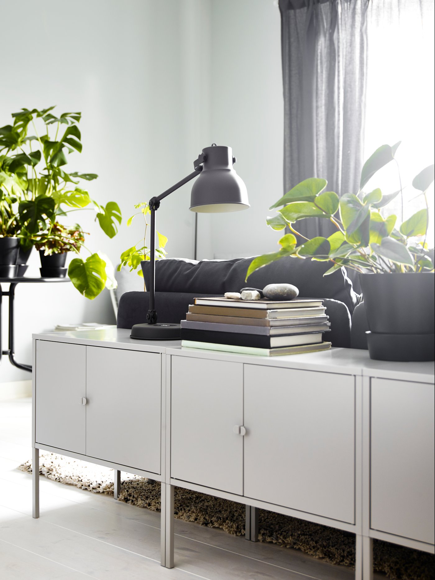 LIXHULT cabinets in the living room with a HEKTAR table lamp behind a SODERHAMN dark grey sofa.  