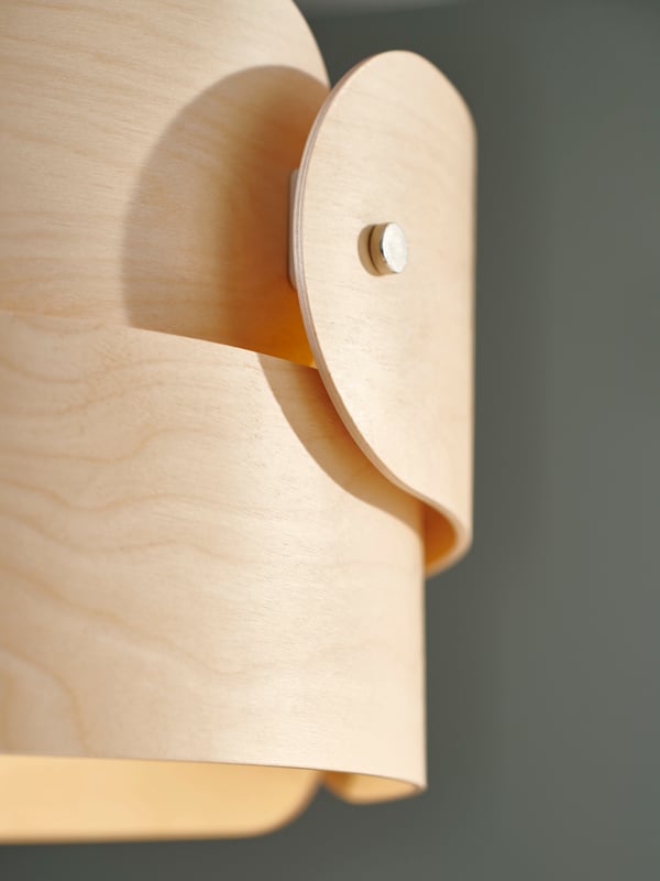 Close-up of the SÖDÅKRA pendant lamp’s overlapping wooden parts and bolt that holds it together.