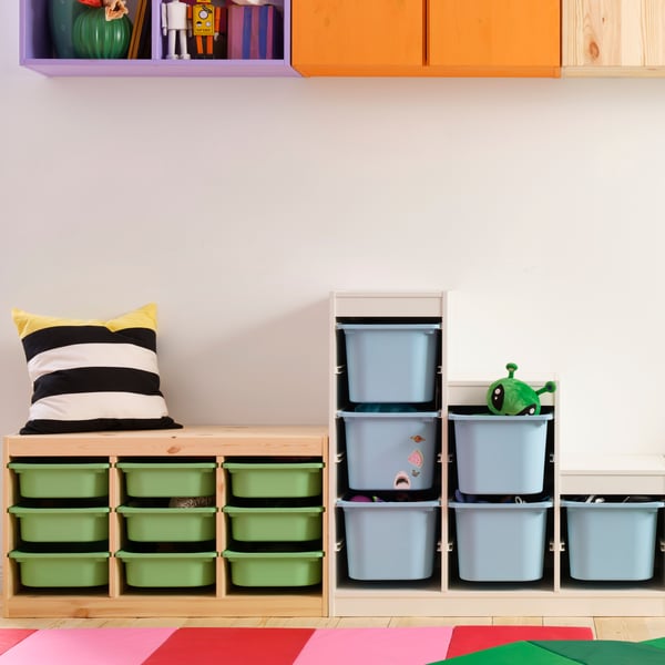 Verschiedene TROFAST Regale mit bunten Boxen stehen in einem Zimmer an einer weißen Wand