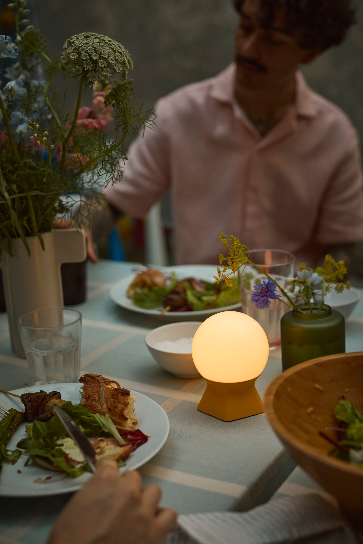 En dekorativ moderne LED-bordlampe med en uvanlig form som hjelper deg med å skape en koselig stemning for utendørsmiddagen.