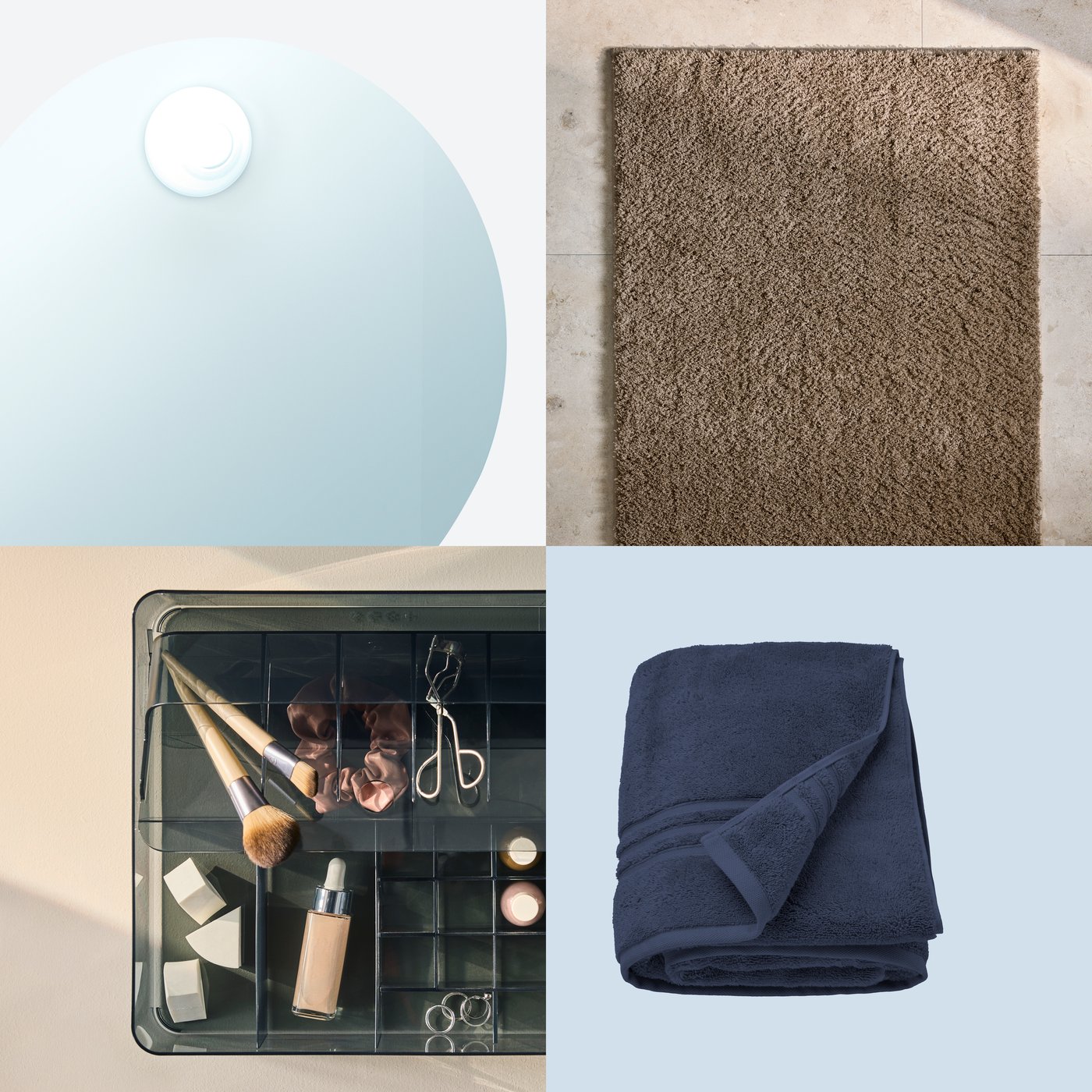 A still life with a brown BACKMÅRA bath rug, a folded blue bath sheet, a mirror with built-in light, and a makeup organiser.