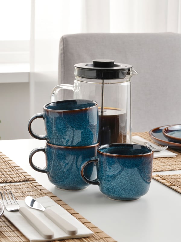 Tazas azules GLADELIG sobre mesa blanca.