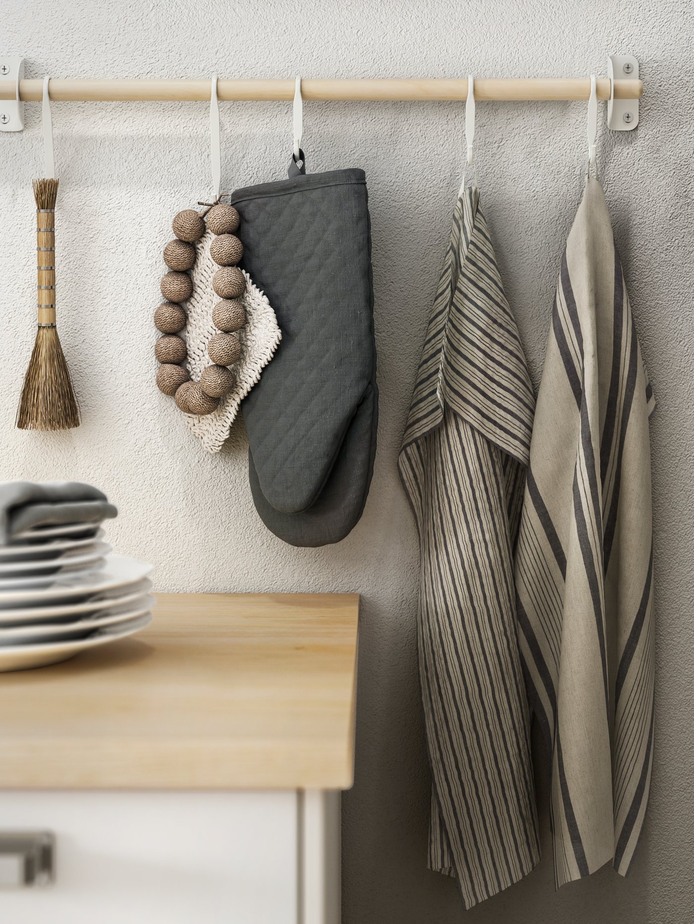 A white NEREBY s-hook on a kitchen rail with kitchen gloves and tea towels hanging off of them