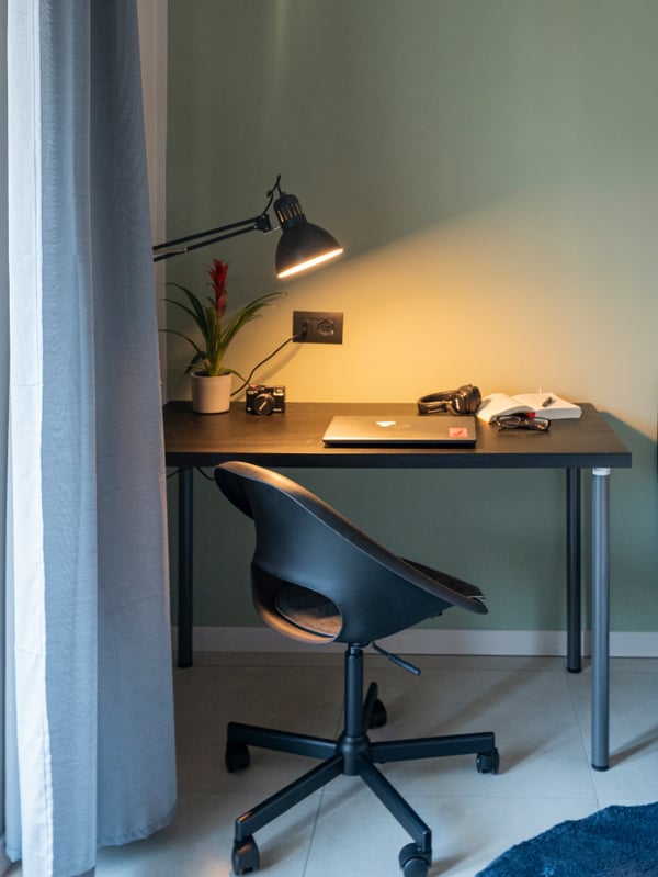 Una postazione dedicata allo studio con scrivania ergonomica SANDSBERG, sedia girevole con altezza regolabile LOBERGET e illuminata da una lampada da lavoro TERTIAL.