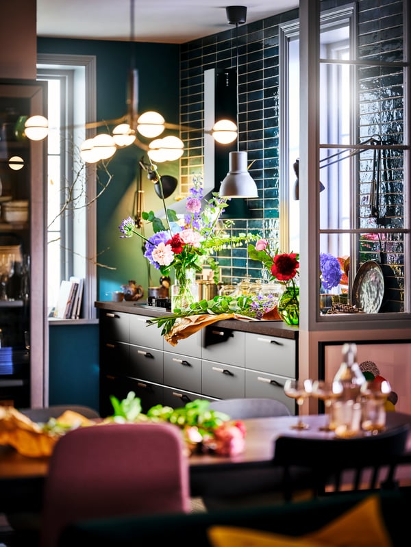 A STORSLINGA LED 8-armed chandelier illuminating a dining area with a KUNGSBACKA anthracite kitchen in the background.