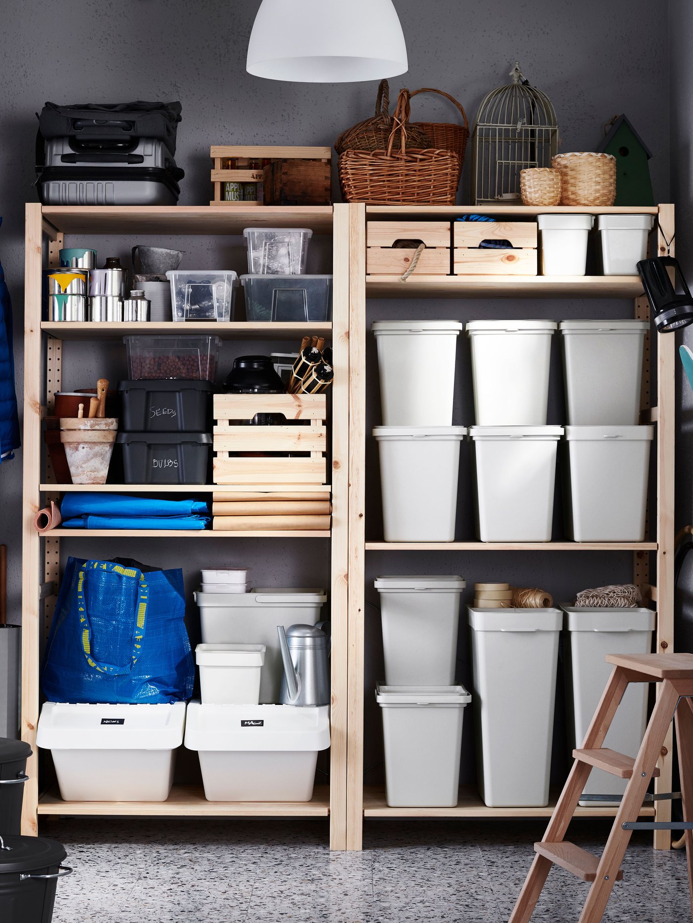 I et bryggers står to reoler ved siden af hinanden på reolens hylder står forskellige HÅLLBAR affaldsspande med låg, to hvide SORTERA affaldsspande og flere kurve i træ og dåser.