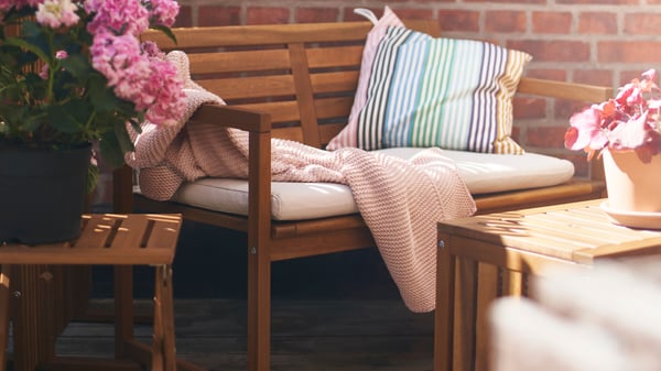 A light brown stained NÄMMARÖ bench with backrest, outdoor
