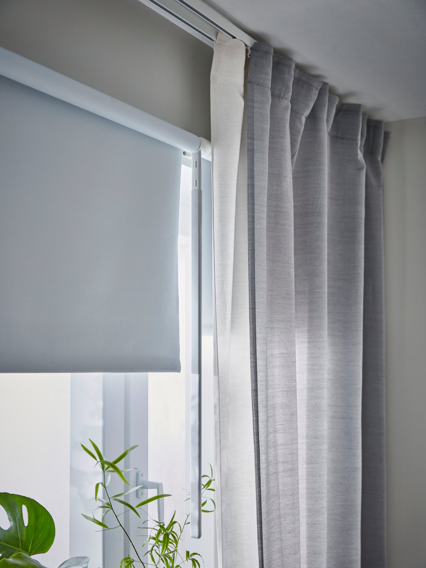 Een VIDGA gordijnrails die aan het plafond is bevestigd met een HILJA gordijn eraan.