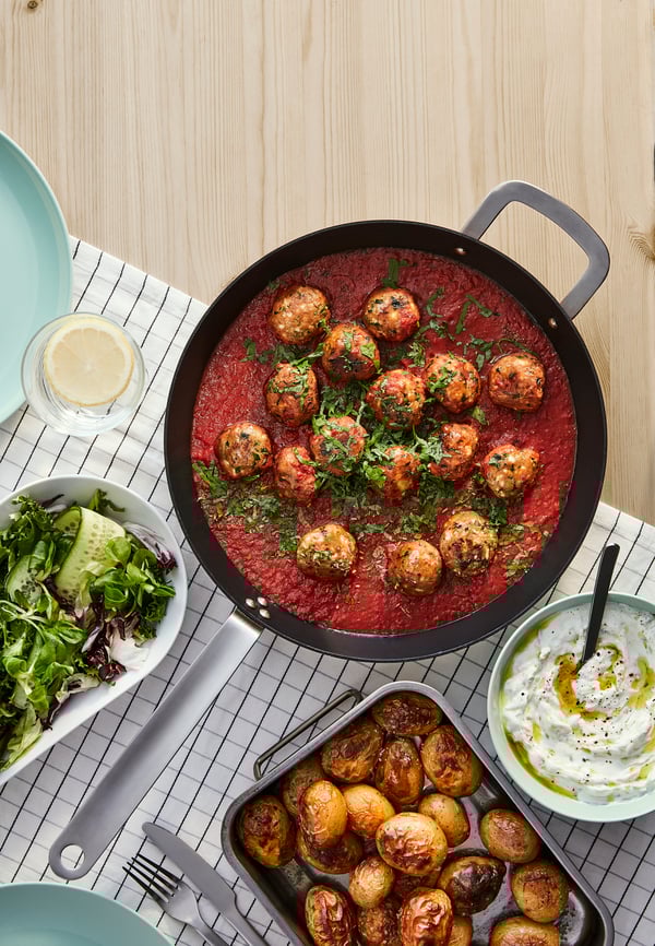 Detalle de albóndigas en una cazuela sobre un paño colocado en una mesa.