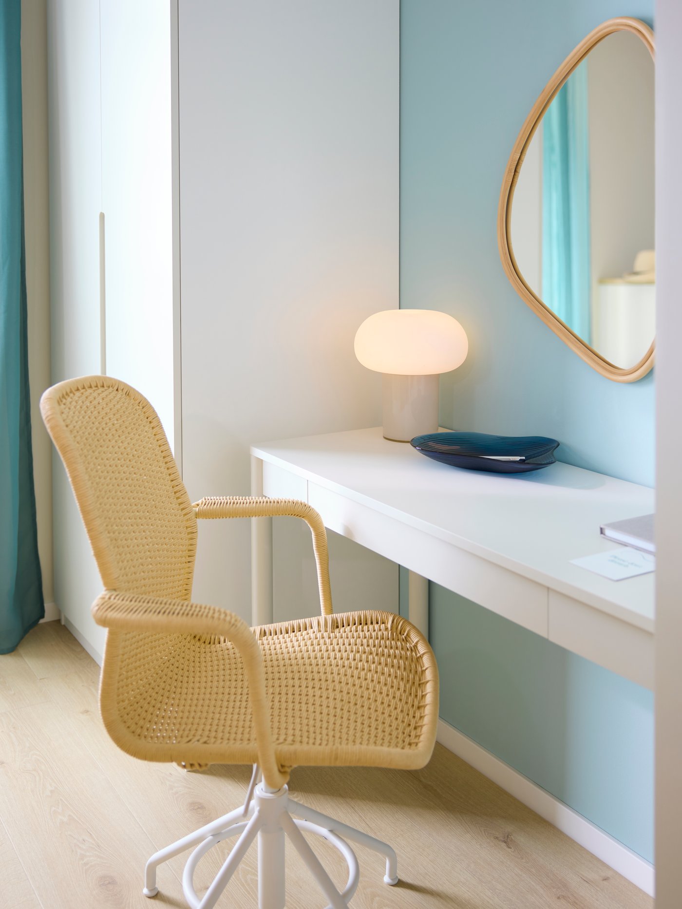 Scrivania TONSTAD stretta color bianco sporco, con cassetto integrato, con sopra una piccola lampada e una ciotola decorativa. Accanto, una sedia con seduta in corda crea un angolo studio essenziale e ordinato.