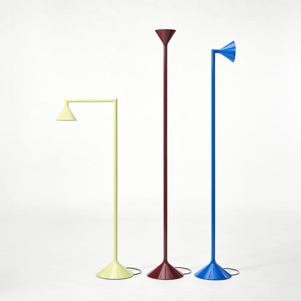 En gul, rød og blå IKEA PS 2026 gulvuplight lampe den gule lampe er bøjet nedad.