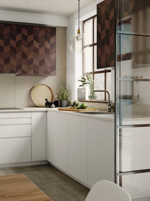 A kitchen featuring a cabinet with white doors, upper cabinets with brown doors, an induction hob, and a base cabinet.