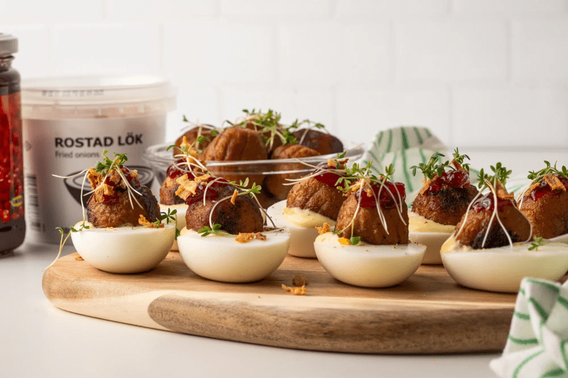 Mit Plantballs gefüllte Eier, die auf einem Holzbrett serviert werden.