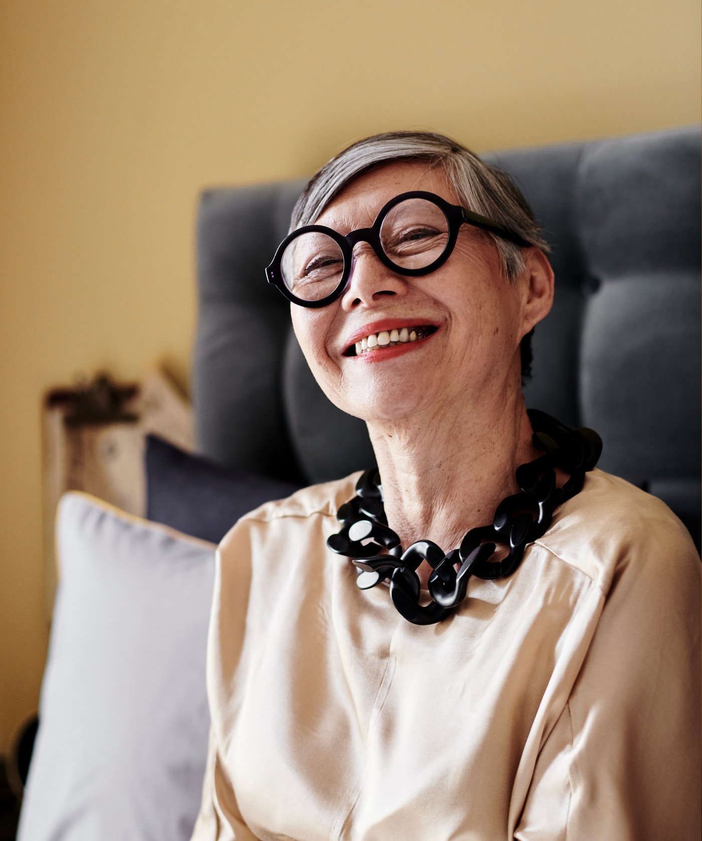Foto einer Frau mit einer schwarzen Brille und einer schwarzen Kette, u. a. mit KONGSFJORD Boxspringbett