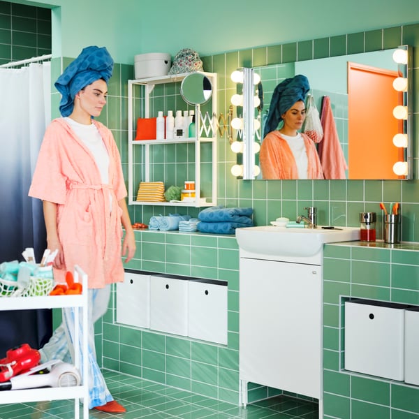 A white KUGGIS storage box in the bathroom