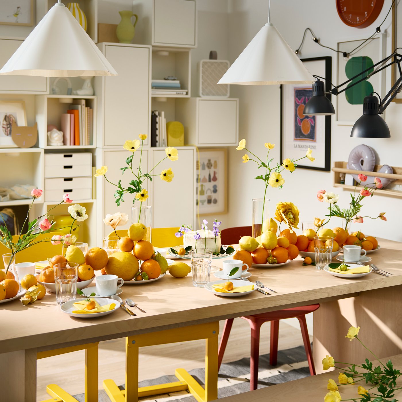 A festive table setting with white plates, POKAL glasses and decorative oranges and lemons on plates on a BERGSHYTTAN table.