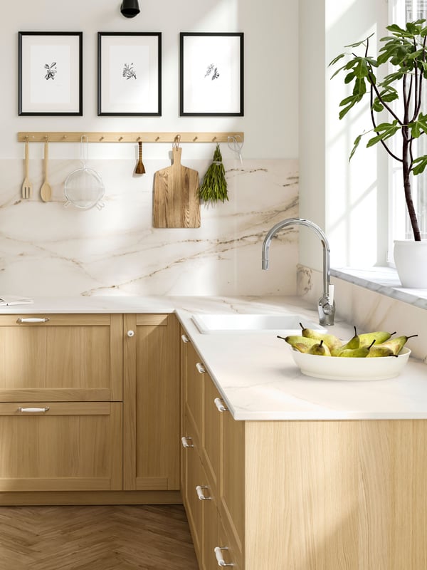 Un plan de travail sur mesure MÖCKLARP en grès cérame haute pression, de couleur blanc cassé mat avec effet marbré, dans la cuisine