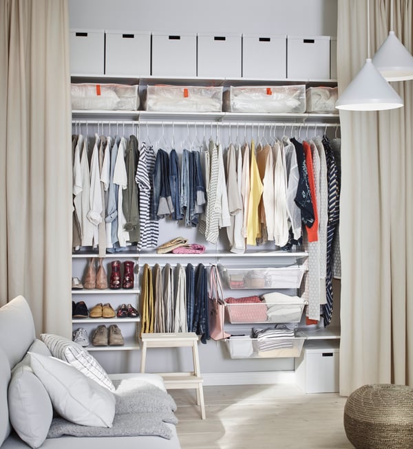 Wit oppbergsysteem waar allemaal kleding zich bevindt.