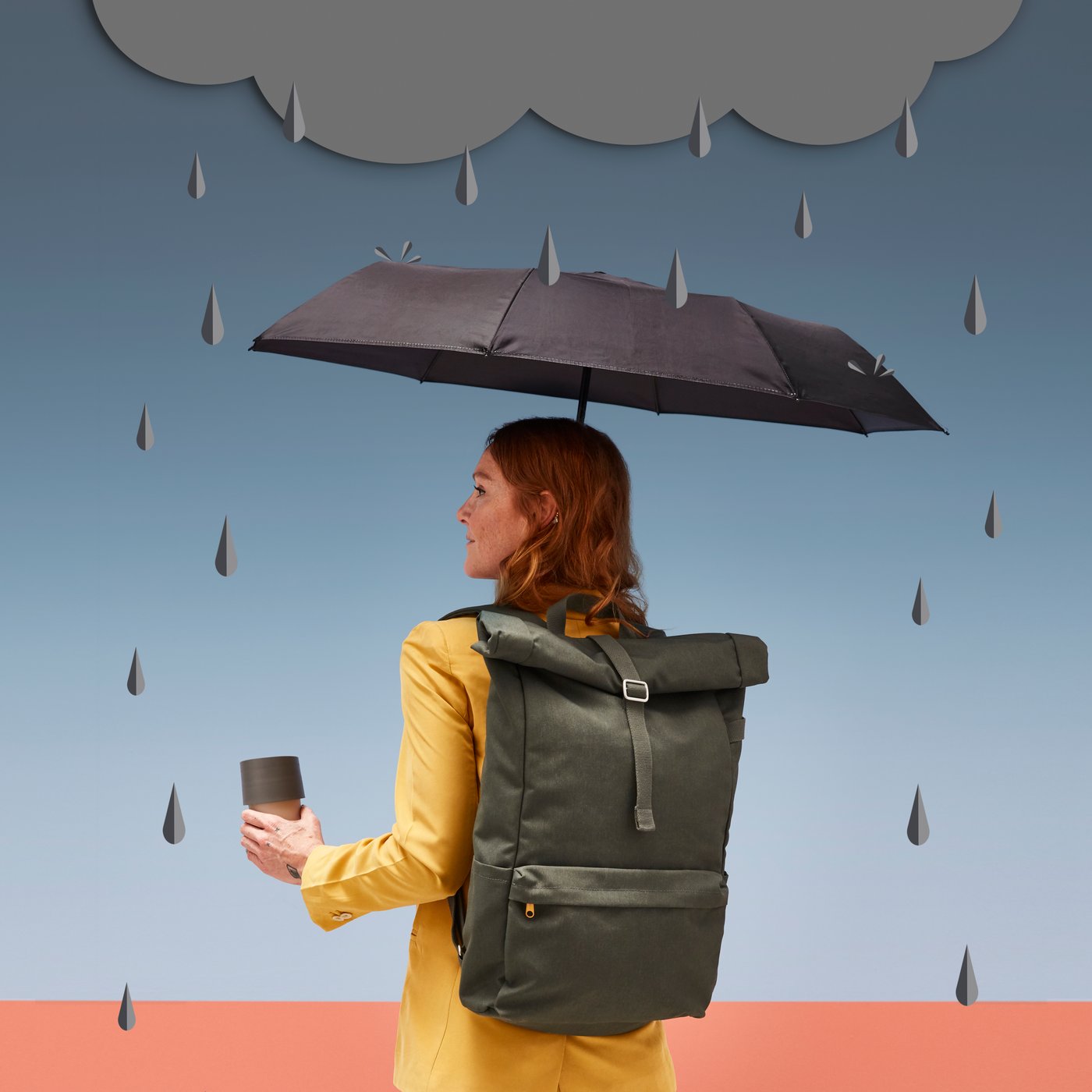 A foldable black KNALLA umbrella in the hallway