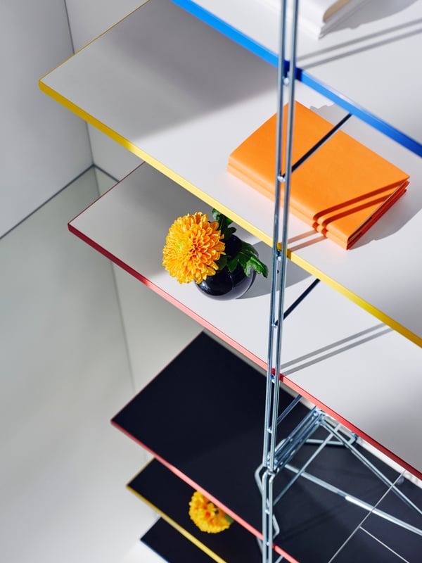 A BYAKORRE open shelving unit with reversible shelves in white and anthracite grey with shelf edges in different colours.