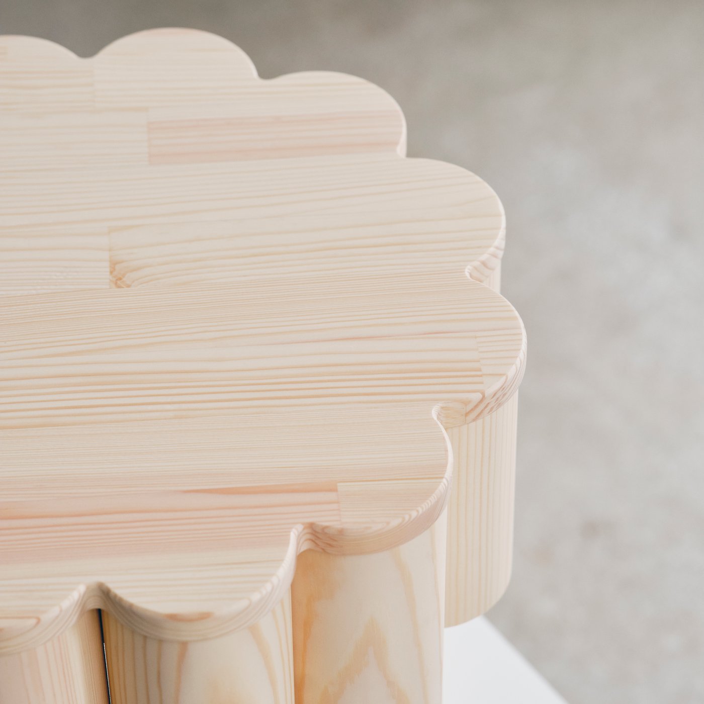 Close up of the top of an stool made from untreated wood in a circular pattern.
