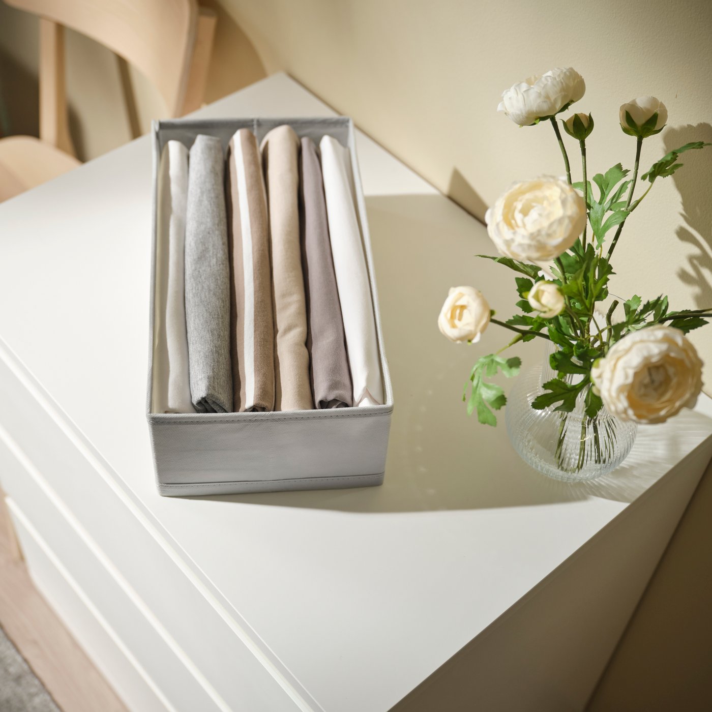 KOSINGEN box 12 cm light grey on top of a chest of drawers. 
