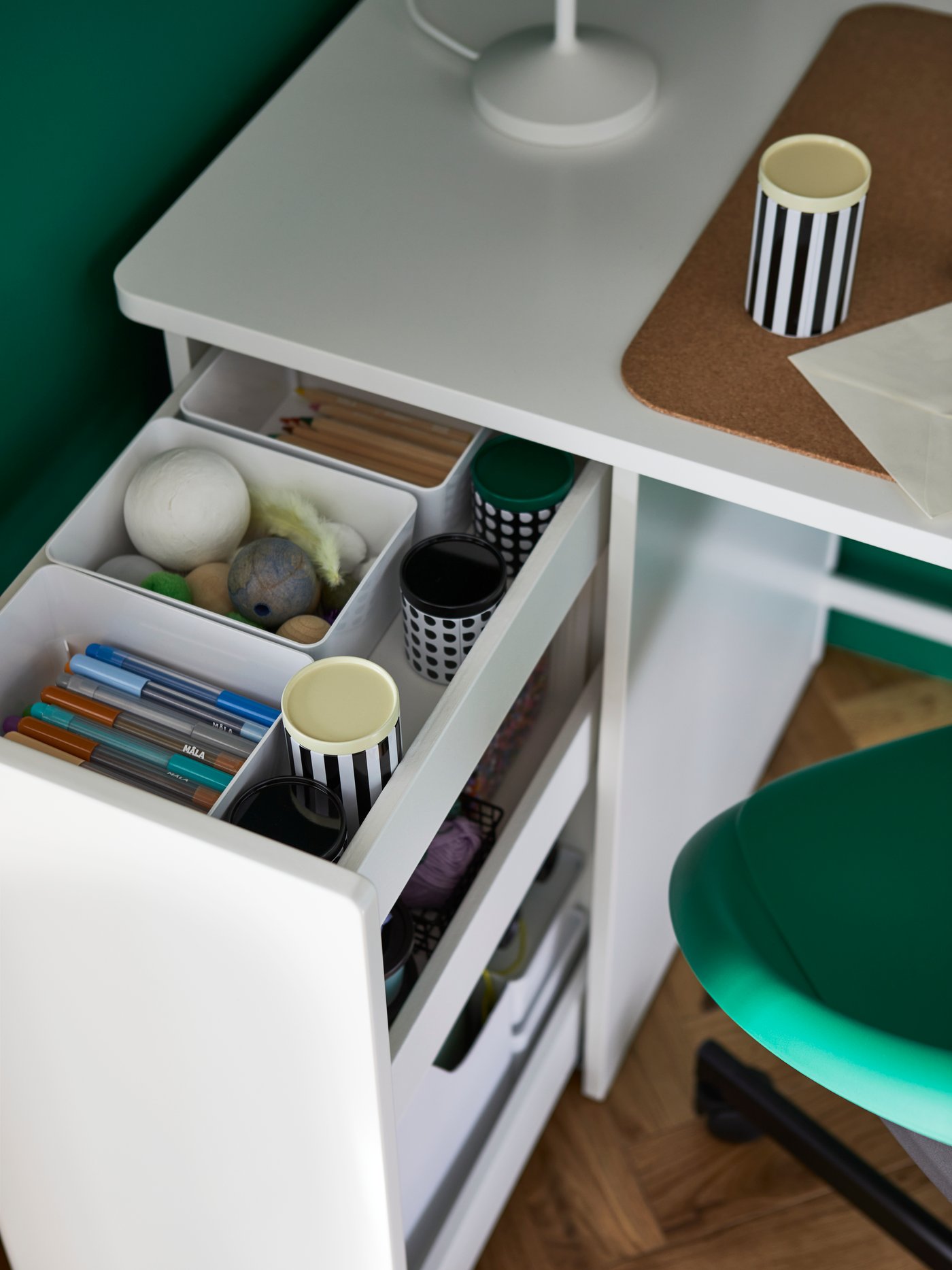 A white LÄRANDE desk with pull out storage unit is open, showing KUGGIS boxes holding tidied pens and other objects.