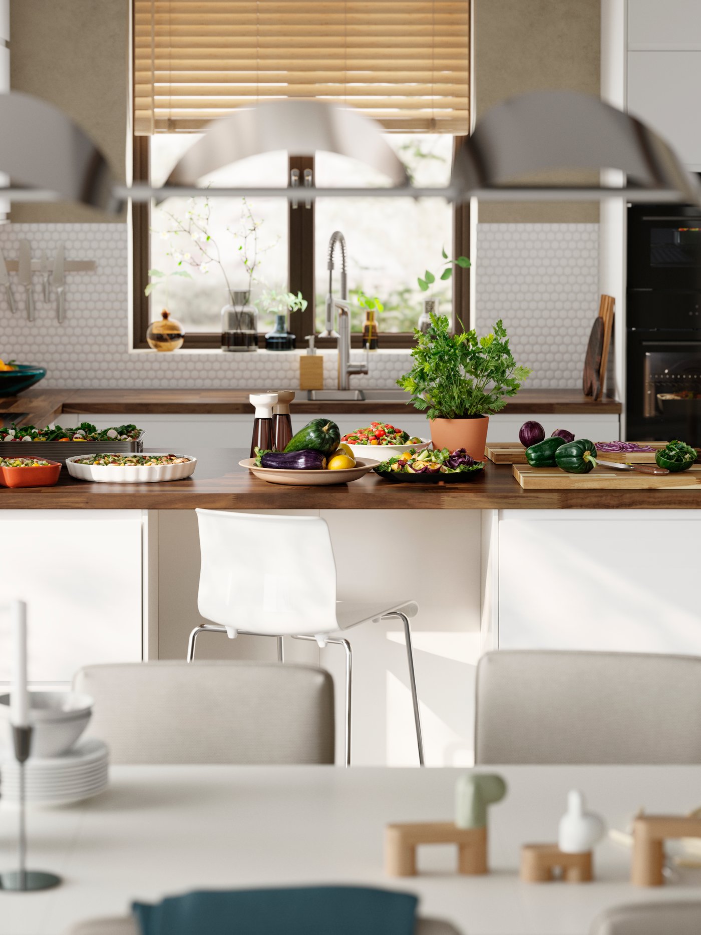 A bright kitchen has matt white VOXTORP fronts and a kitchen peninsula with a white dining table in the foreground.