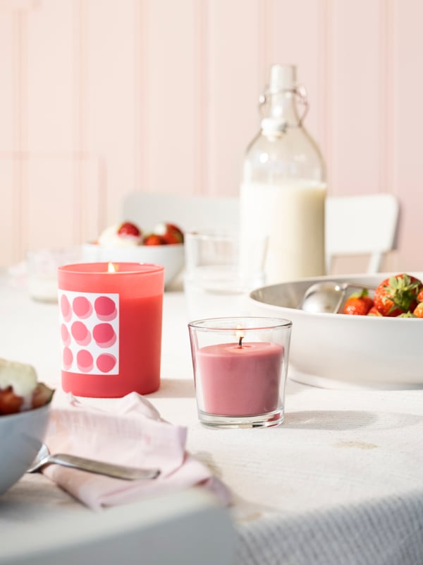 A strawberry/bright pink BLODBOK scented candle in glass