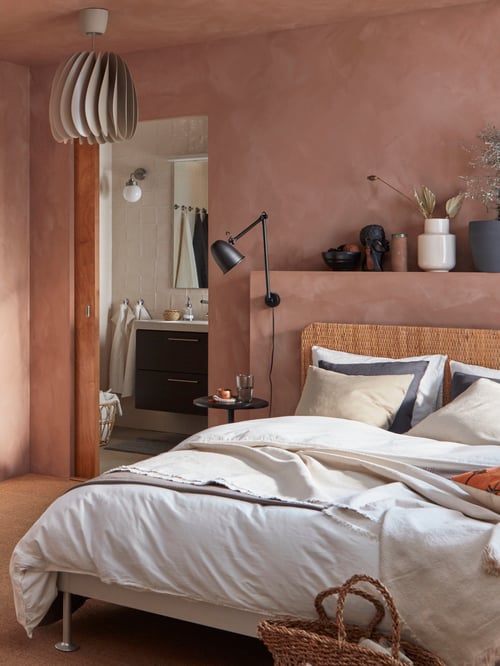 DELAKTIG bed frame together with ÄNGSLILJA duvet and pillowcase in white, in a bedroom with the bathroom door open.