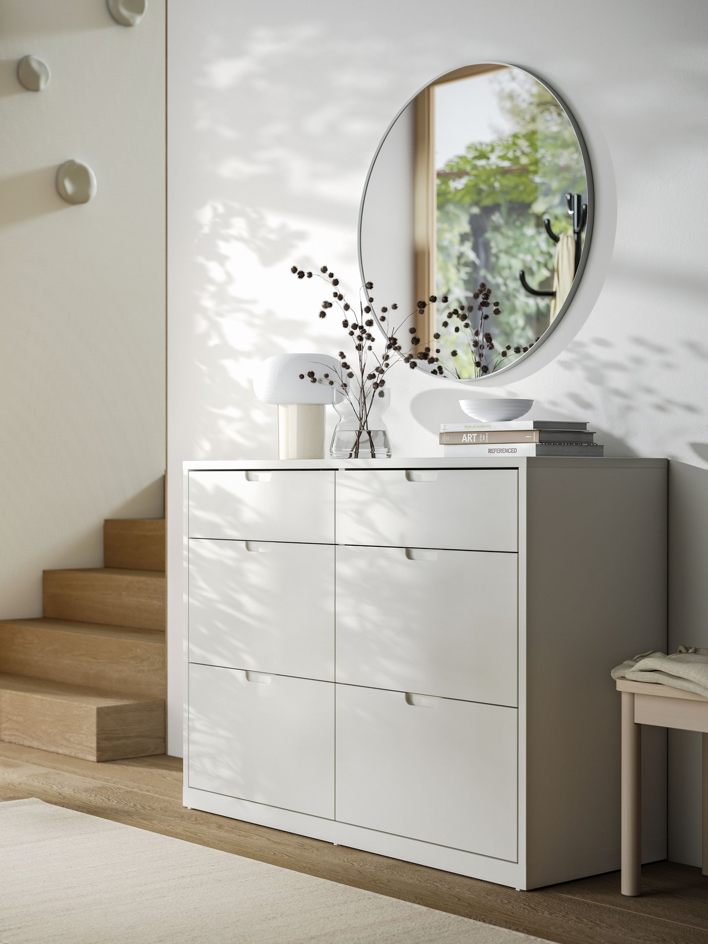 Ein Aluminiumspiegel LINDBYN über einer TONSTAD Kommode in elfenbeinweiß