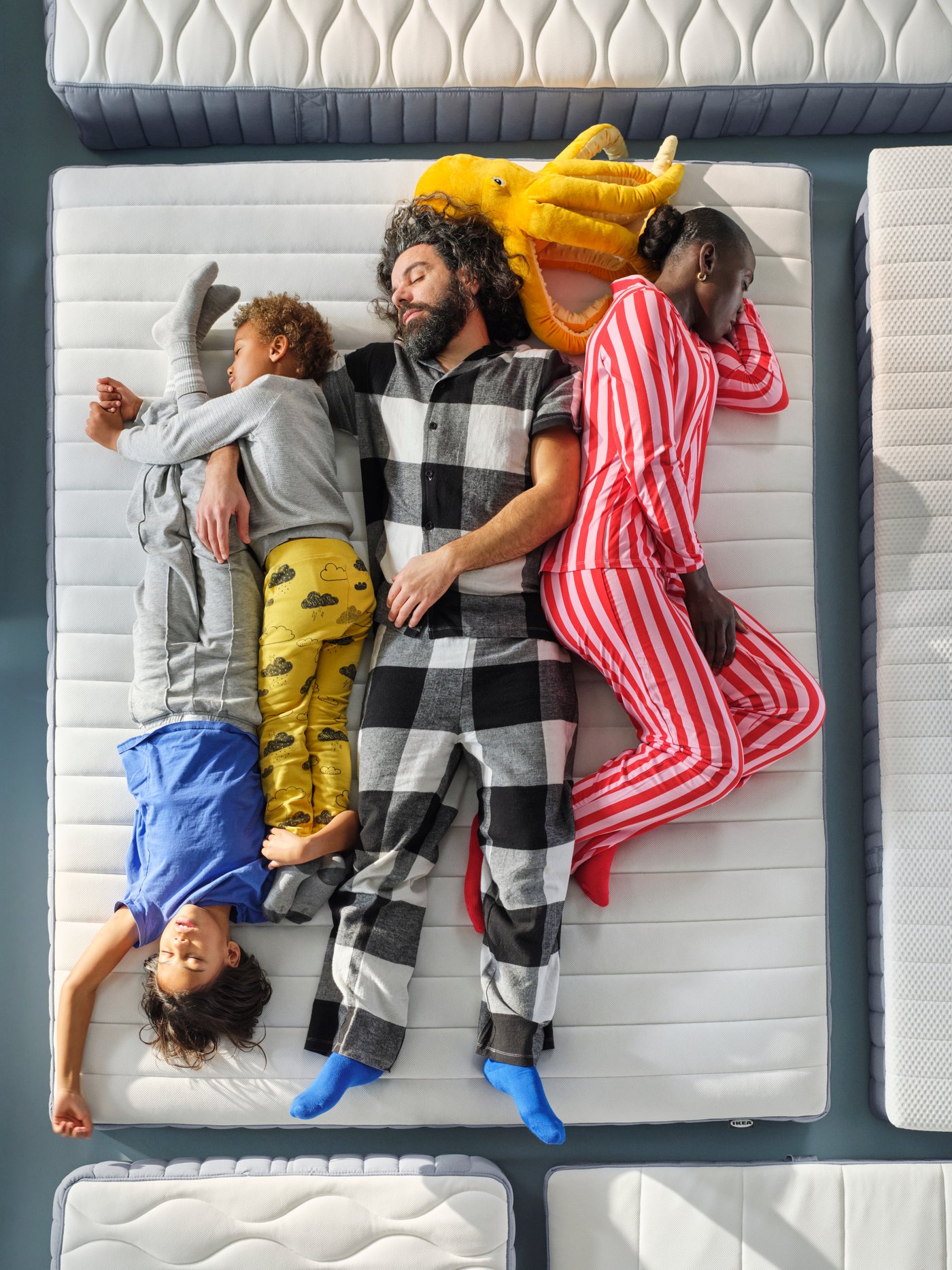 Nahaufnahme einer vierköpfigen Familie in Pyjamas, die den Komfort einer IKEA VALEGÅG Matratze testet.