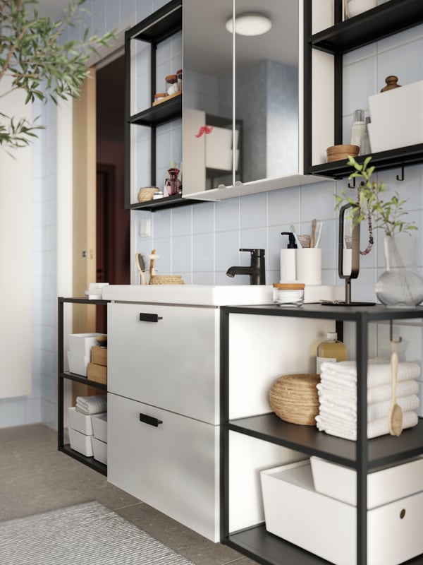 A bathroom wall featuring an ENHET base cabinet for vanity with 2 drawers, open frames with shelves and two mirror doors.
