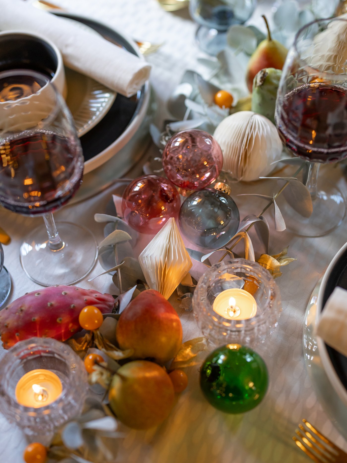 Ein festlich gedeckter Tisch ist mit bunten Christbaum Kugeln geschmückt